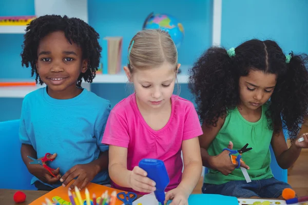 Niños felices haciendo artes y manualidades juntos — Foto de Stock