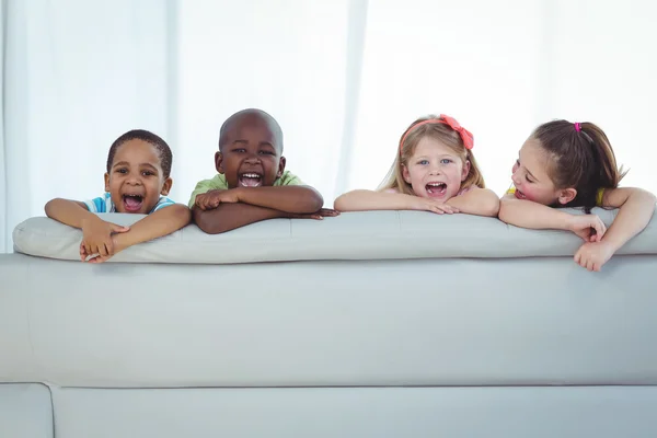 Niños felices mirando desde la parte trasera del sofá —  Fotos de Stock