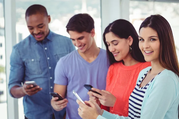 Jeune équipe créative regardant les téléphones — Photo