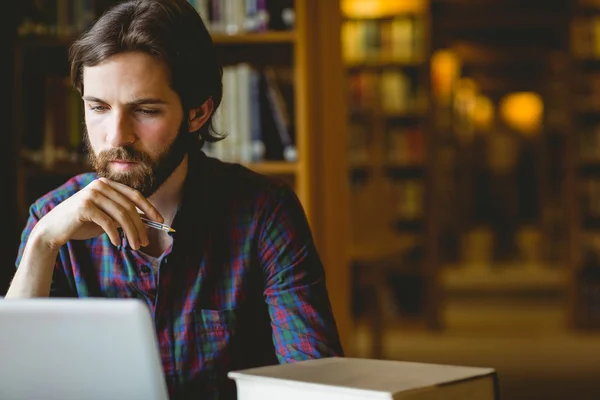 Hipster φοιτητή που σπουδάζει στην βιβλιοθήκη — Φωτογραφία Αρχείου