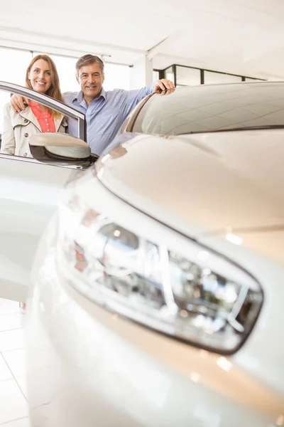 Lachende paar leunend op auto — Stockfoto