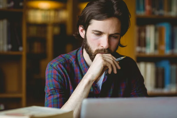 Hipster student studuje v knihovně — Stock fotografie