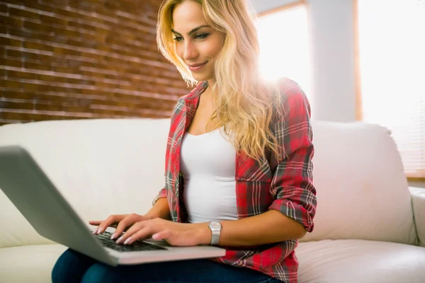 Mooie blonde met behulp van laptop op Bank — Stockfoto