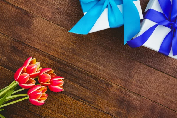 Rode bloemen en blauwe geschenken — Stockfoto