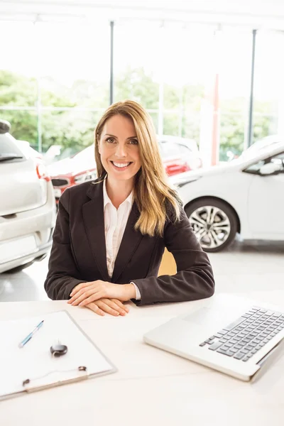 Smiling saleswoman behind her desk — Stock Photo, Image