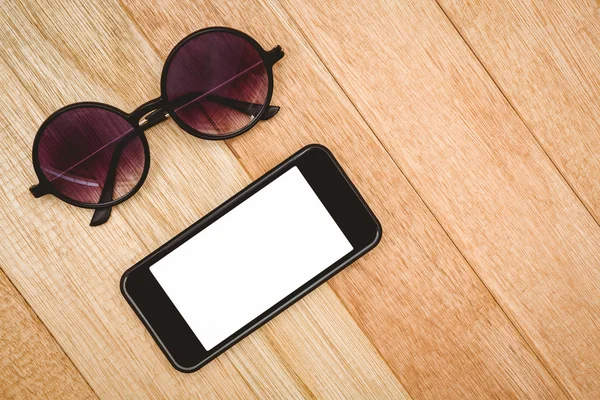 Brille und Smartphone auf Holztisch — Stockfoto