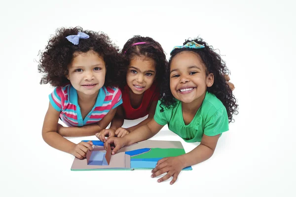 Três meninas com um pequeno livro — Fotografia de Stock