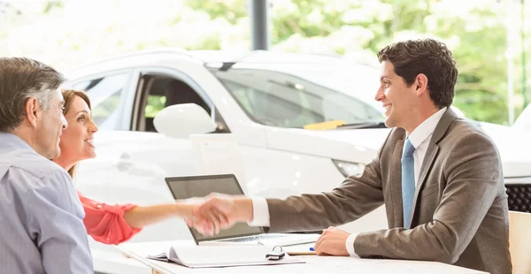 Couple souriant achetant une nouvelle voiture — Photo