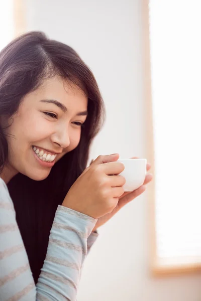 アジアの女性がコーヒーを飲みながらソファでリラックス — ストック写真