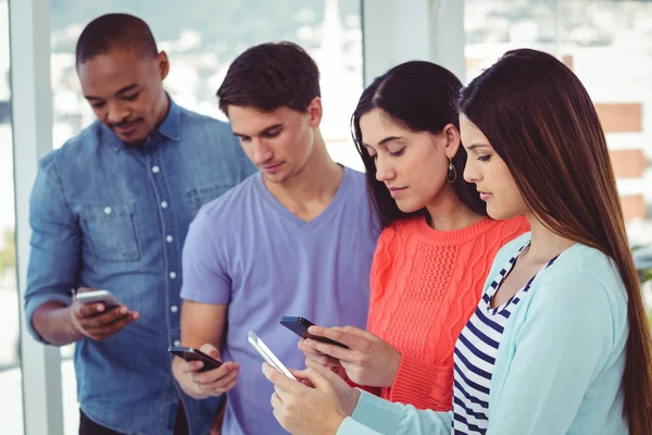 Unga kreativa team tittar på telefoner — Stockfoto