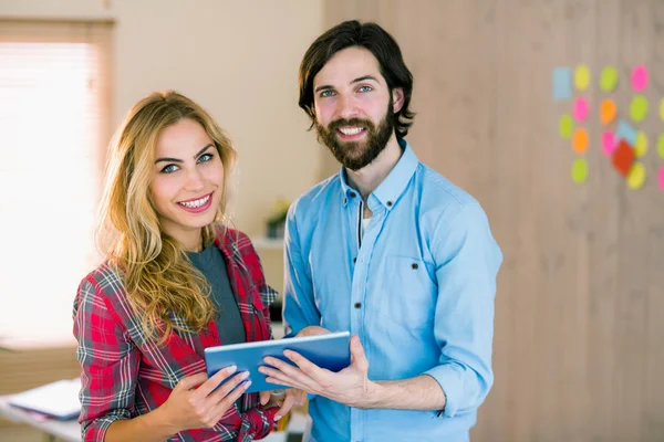 Kreatives Team schaut gemeinsam auf Tablet — Stockfoto