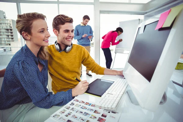 Graphic designer wearing headphones at desk — Stock Photo, Image