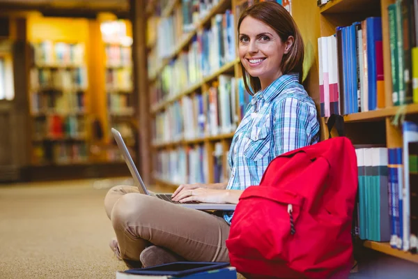 Ώριμη φοιτήτρια στη βιβλιοθήκη χρησιμοποιώντας φορητό υπολογιστή — Φωτογραφία Αρχείου