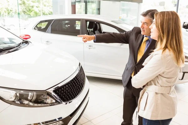 Vendeur montrant une voiture à un client — Photo