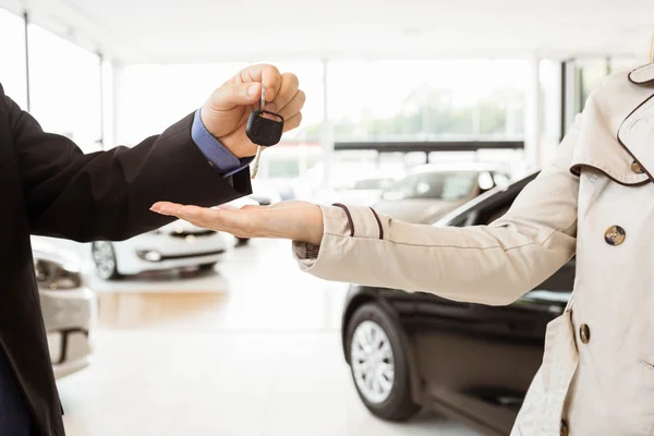 Verkäufer bietet einem Kunden Autoschlüssel an — Stockfoto