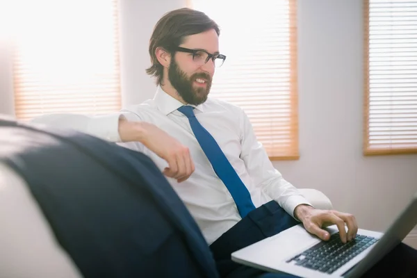 Empresário usando laptop no sofá — Fotografia de Stock