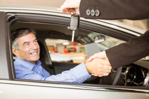 Customer receiving car keys while shaking hand — Stock Photo, Image