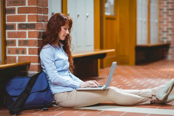 Volwassen student met behulp van laptop in gang — Stockfoto