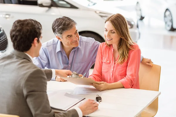 Smiling couple buying a new car — Stock Photo, Image