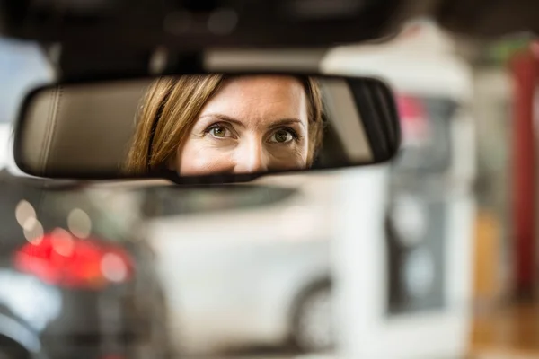 Mulher no banco dos motoristas olhando no espelho — Fotografia de Stock