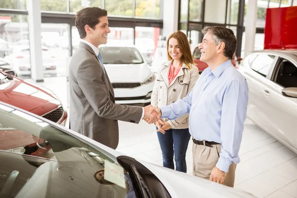 Empresário sorridente apresentando um carro — Fotografia de Stock