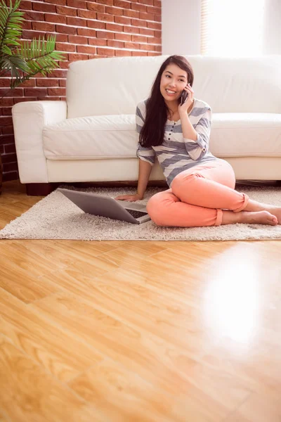 Asian woman using phone on floor — Stock Photo, Image