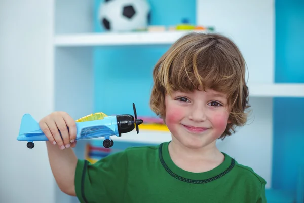 Kleine jongen een vlak stuk speelgoed bedrijf — Stockfoto