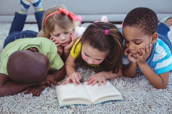 Crianças felizes lendo um livro juntas — Fotografia de Stock