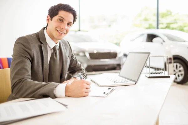 Vendedor sorridente atrás de sua mesa — Fotografia de Stock