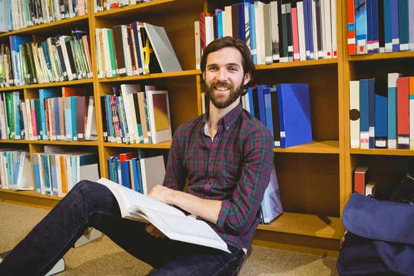 Student reading book in library on floor — Stock Photo, Image