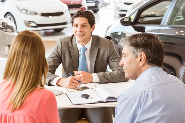 Lachende paar een nieuwe auto kopen — Stockfoto