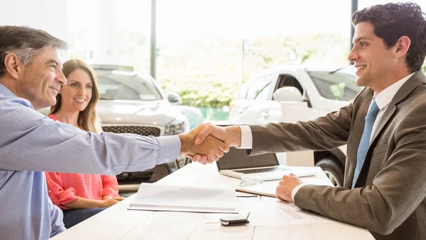 Sonriente pareja comprando un coche nuevo — Foto de Stock