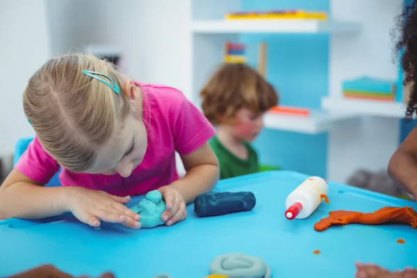 Bambini sorridenti usando argilla modellante — Foto Stock