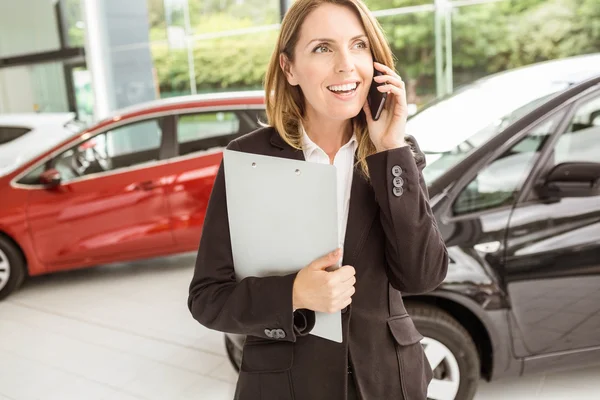 Lachende verkoopster met een telefoongesprek — Stockfoto