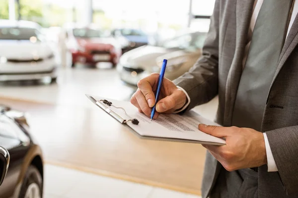 Hombre de negocios enfocado mirando la carrocería del coche —  Fotos de Stock