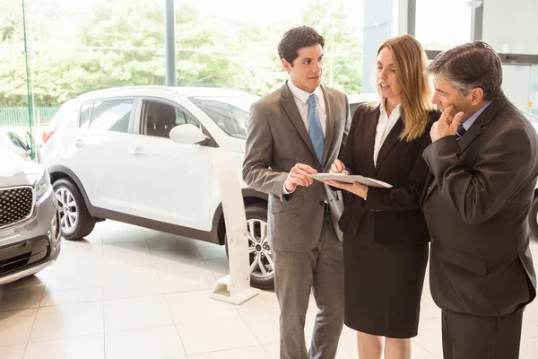 Equipo de ventas mira un portapapeles — Foto de Stock