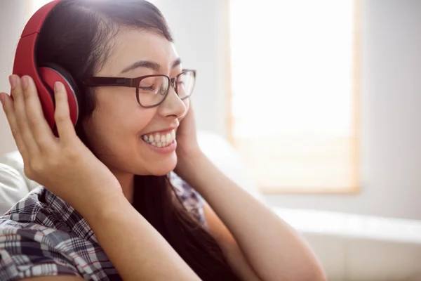 Aziatische vrouw op de Bank luisteren naar muziek — Stockfoto