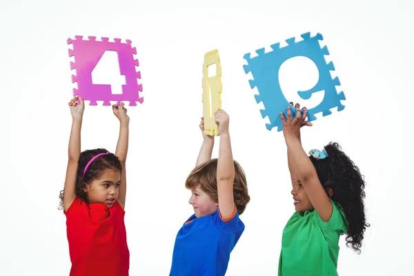 Three kids holding number shanpes above their heads — Stock Photo, Image