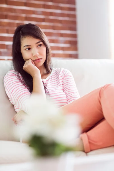 Naštvaná asijské žena na gauči — Stock fotografie
