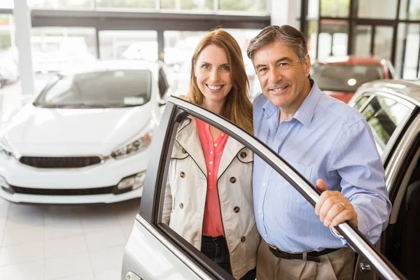 Couple souriant appuyé sur la voiture — Photo