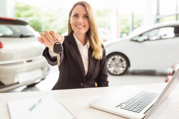 Sorrindo vendedora segurando chave do carro — Fotografia de Stock