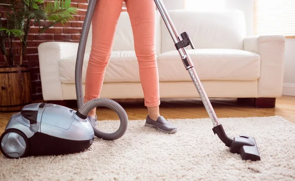 Žena hoovering koberec — Stock fotografie