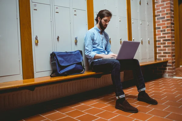 Étudiant hipster utilisant un ordinateur portable dans le couloir — Photo