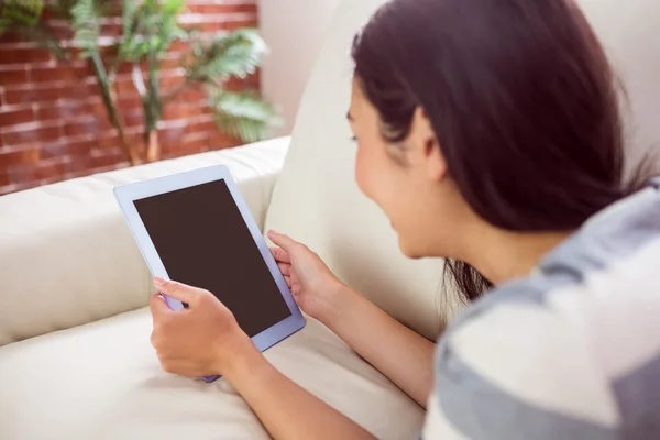 Sorrindo mulher asiática no sofá usando tablet — Fotografia de Stock