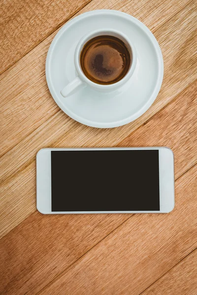 Caffè e smartphone sulla scrivania in legno — Foto Stock