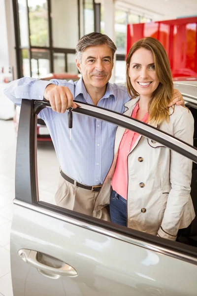 Uśmiechający się para opierając się na samochód — Zdjęcie stockowe