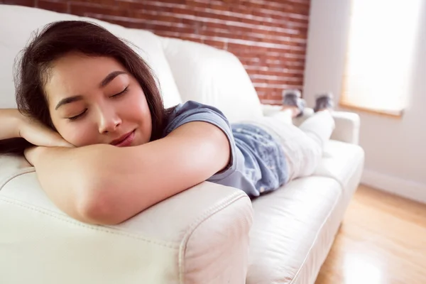 Азиатка дремлет на диване — стоковое фото
