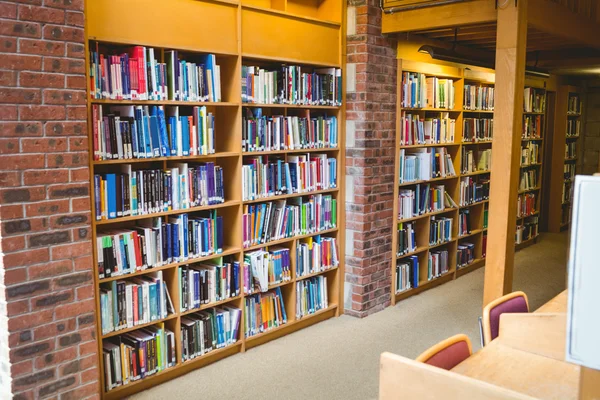 Estudiante leyendo un libro de estantería en la biblioteca —  Fotos de Stock