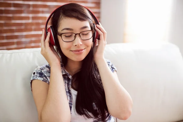 Asiatisk kvinna på soffan lyssna på musik — Stockfoto