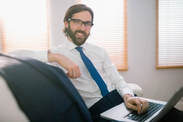 Empresário usando laptop no sofá — Fotografia de Stock